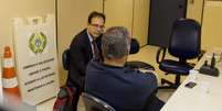 Em delegacia no Rio de Janeiro, Raymond Whelan conversa com o advogado após a prisão  Foto: Daniel Ramalho / Terra