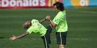 David Luiz e Daniel Alves durante aquecimento; Brasil enfrenta primeira seleção campeã do mundo na Copa   Foto: Leo Correa / AP