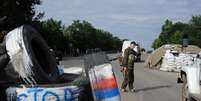 <p>Militantes pró-russos guardam um posto de controle, na estrada entre Lugansk e Donetsk, no leste da Ucrânia, em 9 de julho</p>  Foto: Dominique Faget / AFP