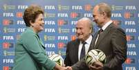 <p>Dilma passa, simbolicamente, a Putin a sede da Copa do Mundo durante uma cerimônia no Rio de Janeiro</p>  Foto: Alexey Nikolsky / RIA Novosti / Kremlin / Reuters
