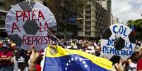 Cartaz usado em uma das manifestações diz: chute a repressão  Foto: Carlos Garcia  / Reuters