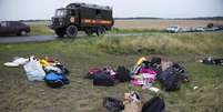 <p>Bagagem dos passageiros é recolhida no local onde o avião de passageiros da Malaysia Airlines caiu perto da aldeia de Rozsypne, no leste da Ucrânia, nesta quinta-feira, 17 de julho</p>  Foto: Dmitry Lovetsky / AP