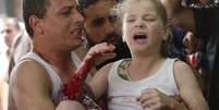 <p>Um palestino carrega uma menina ferida na sala de emergência do Hospital Shifa, no norte da Faixa de Gaza, em 20 de julho</p>  Foto: Lefteris Pitarakis / AP