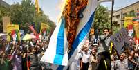 <p>Manifestantes queimam uma bandeira de Israel durante os protestos de 25 de julho</p>  Foto: Ebrahim Noroozi / AP