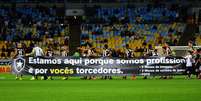 <p>Jogadores do Botafogo carregam faixa de protesto no Maracanã</p>  Foto: Marcello Dias / Futura Press
