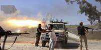 <p>Combatentes da brigada islâmica Misarata atiram contra o aeroporto de Trípoli na tentativa de tomar o controle da região, dominada por uma poderosa milícia rival, em 26 de julho</p>  Foto: AP