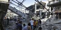 <p>Palestinos observam os destroços da torre de uma mesquita que, segundo policiais, foi destruída por um ataque aéreo israelense, na Faixa de Gaza, em 30 de julho </p>  Foto: Finbarr O'Reilly / Reuters