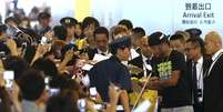 Neymar dá autógrafos a crianças e jovens em aeroporto do Japão  Foto: AP