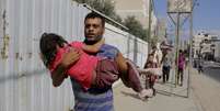 <p>Um palestino carrega sua filha durante fuga logo&nbsp;ap&oacute;s um ataque a&eacute;reo israelense contra um pr&eacute;dio&nbsp;em Rafah, em&nbsp;31 de julho</p>  Foto: Hatem Al / AP