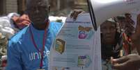<p>Um trabalhador UNICEF segura&nbsp;um cartaz com informa&ccedil;&otilde;es para evitar o ebola em Conacri, capital da Guin&eacute;</p><p>&nbsp;</p>  Foto: UNICEF/La Rose / Reuters