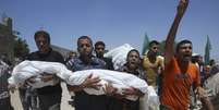 <p>Palestinos carregam os corpos de crian&ccedil;as mortas durante ataques israelenses no sul da Faixa de Gaza, em 29 de julho</p>  Foto: Ibraheem Abu Mustafa / Reuters