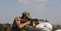 <p>Um militar ucraniano dispara seu rifle para verificar sua precis&atilde;o, em um posto de controle perto da cidade de Debaltseve, na regi&atilde;o de Donetsk, em 2 de agosto</p>  Foto: Valentyn Ogirenko / Reuters