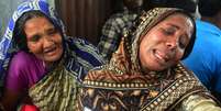 Mulher chora por ter irmão desaparecido em acidente com embarcação em Bangladesh  Foto: Munir uz ZAMAN / AFP