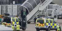 Homem é retirado pela polícia de um avião da Qatar Airways no aeroporto de Manchester, na Inglaterra. 5/08/2014.  Foto: Andrew Yates / Reuters