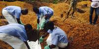 <p>Volunt&aacute;rios enterram o corpo de uma pessoa infectada pelo&nbsp;v&iacute;rus Ebola, em uma sepultura em Kailahun, em&nbsp;2 de agosto</p>  Foto: WHO/Tarik Jasarevic / Reuters