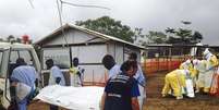 <p>Voluntários carregam corpos em um centro liderado pelo grupo Médico Sem Fronteiras para pacientes com Ebola, em Kailahun, Serra Leoa, em 2 de agosto</p>  Foto: OMS / Reuters