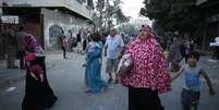Palestinos carregam alguns pertences enquanto deixam suas casas em Gaza, após fim de trégua  Foto: Mohammed Salem / Reuters