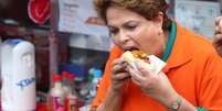 Presidente e candidata à reeleição pelo PT, Dilma Rousseff come cachorro-quente em Osasco, na região metropolitana de São Paulo, durante agenda de campanha na cidade  Foto: Marcos Bezerra/Futura Press