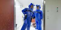 Agentes de saúde na Alemanha limpam ambiente onde estão internados pacientes em quarentena  Foto: Reuters