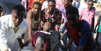Um homem ferido &eacute; levado para hospital ap&oacute;s confrontos que deixaram pelo menos 11 mortos na Som&aacute;lia nesta sexta-feira  Foto: MOHAMED ABDIWAHAB / AFP
