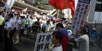 <p>Milhares de manifestantes estavam vestidos de vermelho como forma de marcar sua lealdade a Pequim</p>  Foto: Liau Chung-ren / Reuters