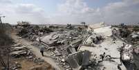 <p>Uma mulher palestina caminha entre as ruínas de casas em Jöhr El-Deek, na Faixa de Gaza, em 17 de agosto</p>  Foto: Ibraheem Abu Mustafa / Reuters