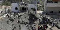 <p>Palestinos observam&nbsp;uma cratera aberta&nbsp;ap&oacute;s uma casa ser atingida&nbsp;por um ataque a&eacute;reo israelense&nbsp;no norte da Faixa de Gaza, em 22 de&nbsp;agosto</p>  Foto: Adel Hana / AP