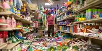 <p>A funcionária de um supermercado se depara com as prateleiras do estabelecimento totalmente desorganizadas após o terremoto que atingiu a cidade neste domingo</p>  Foto: Alex Washburn / Reuters
