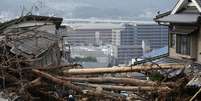 <p>Policial busca por sobreviventes em uma área residencial em Asaminami, Hiroshima, em 23 de agosto</p>  Foto: Toru Hana / Reuters