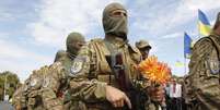 Soldado segura flor durante cerimônia na Ucrânia  Foto: Valentyn Ogirenko  / Reuters
