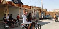 <p>Moradores de Tabqa erguem bandeira do Estado Islâmico perto de Raqqa</p>  Foto: Stringer / Reuters