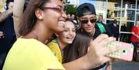 <p>Neymar e David Luiz tiraram fotos com crianças na frente do hotel</p>  Foto: Bruno Domingos/Mowa Press / Divulgação