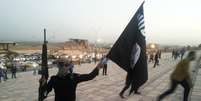 <p>Um integrante do Estado Islâmico exibe uma bandeira do grupo terrorista em uma rua da cidade de Mossul, em 23 de junho</p>  Foto: Reuters