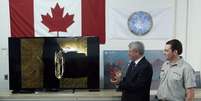 Primeiro-ministro do canadá, Stephen Harper (à esquerda) aplaude após ser apresentado às imagens dos destroços encontrados  Foto: Chris Wattie  / Reuters