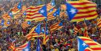 <p>Pessoas levantam bandeiras da Catalunha em manifestação que marcou o dia da Catalunha</p>  Foto: Albert Gea / Reuters