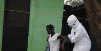 Agente de saúde leva paciente para centro de tratamento na Libéria  Foto: James Giahyue / Reuters