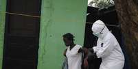 <p>Agente de saúde ajuda paciente com ebola na Libéria</p>  Foto: James Giahyue / Reuters