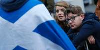 <p>Casal do lado de fora do Parlamento da Escócia, em Edimburgo, após referendo sobre a independência</p>  Foto: Russell Cheyne / Reuters