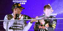 No pódio, Hamilton comemora importante vitoria ao lado do rival Vettel, da Red Bull  Foto: Toshifumi Kitamura / AFP