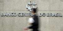 <p>Homem passa pela logomarca do Banco Central na sede do banco em Bras&iacute;&shy;lia</p>  Foto: Ueslei Marcelino / Reuters