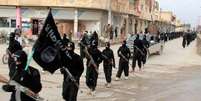 <p>Combatentes do grupo Estado Islâmico marcham em Raqqa, na Síria</p>  Foto: AP