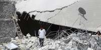 Menino anda entre escombros de prédio destruído durante ataques desta terça-feira  Foto: Ammar Abdullah  / Reuters