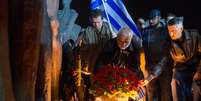 <p>Manifestante coloca flores em frente ao monumento&nbsp;Trag&eacute;dia dos povos</p>  Foto: Alexander Utkin / AFP