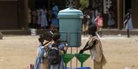 Crianças lavam as mãos após a instalação para prevenir contágio de ebola em uma escola na Costa do Marfim  Foto: Luc Gnago / Reuters