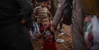 Criança curda chora ao chegar na Turquia após fugir com família de confrontos no território sírio  Foto: BULENT KILIC / AFP