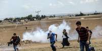 Dezenas de milhares de curdos sírios invadiram a Turquia, fugindo um ataque pelo Estado islâmico  Foto: BULENT KILIC / AFP