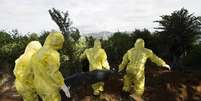 <p>Coveiros enterram vítimas do ebola em Serra Leoa</p>  Foto: Christopher Black / Reuters