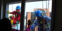 <p>Heróis param em janelas de crianças doentes e acenam para os pequenos</p>  Foto: Fábio Santos / Terra