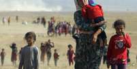 Mulheres e crianças yazidis caminham para fronteira do Iraque  Foto: Rodi Said / Reuters