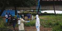 <p>Agente da saúde com vestimenta especial é desinfetado após lidar com um corpo infectado com ebola, em Monróvia, na Libéria</p>  Foto: James Giahyue / Reuters